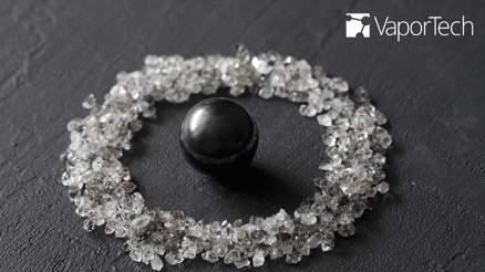 Photo of a graphite sphere surrounded by cut diamonds